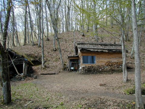 森の入り口にある松木小屋（右）、左側に見えるのは炭焼き用の窯。